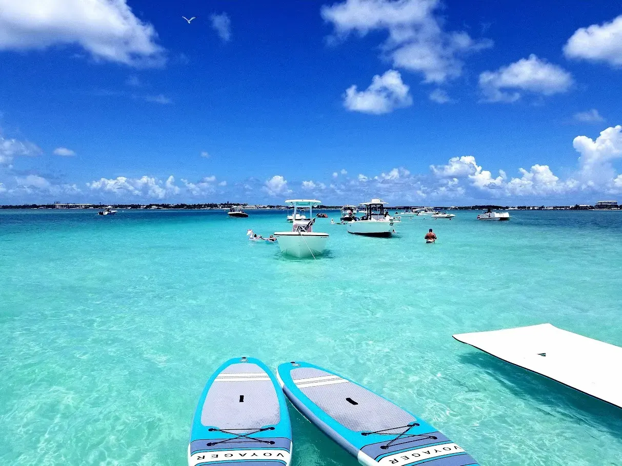 Several boats anchored at an Islamorada sandbar with paddleboards