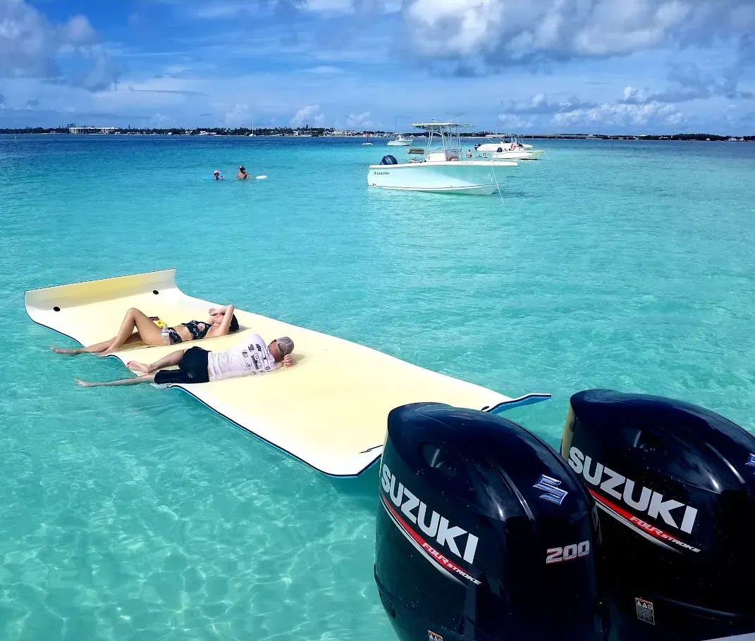 Couple relaxing in the sun on a water mat Islamorada sandbar