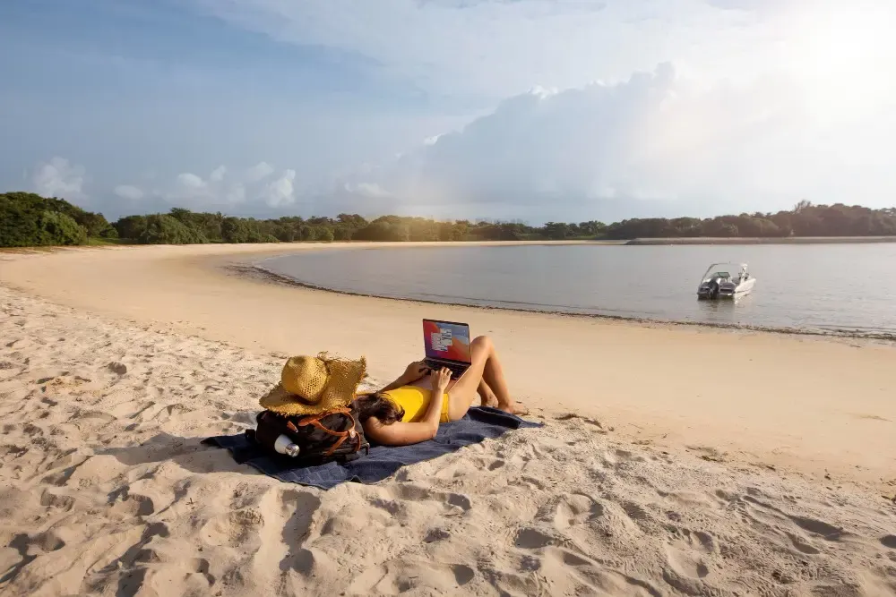 Woman working on a laptop at the beach