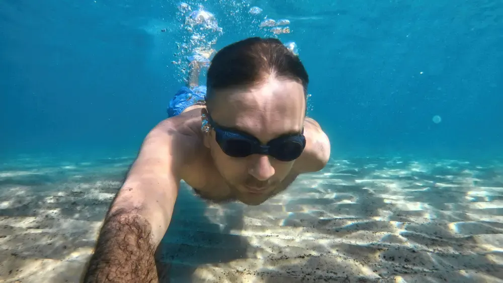 Man snorkeling with a mask in clear ocean water