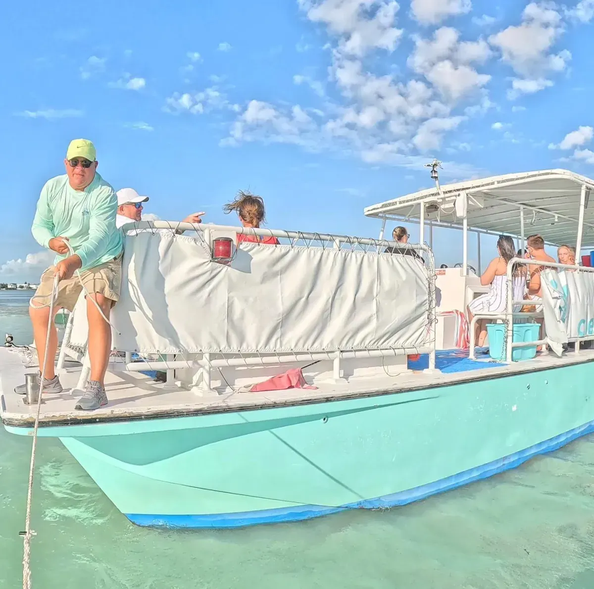 A happy guest in a sun hat enjoying a drink while relaxing in the clear waters of Islamorada