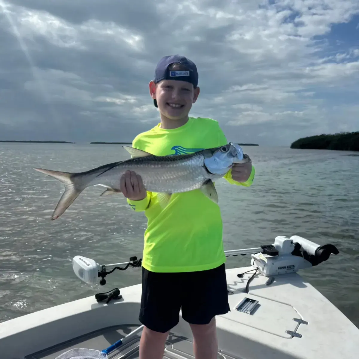 Boy holding up a fish he caught on a Clearly Unique Charters trip