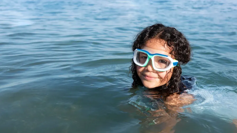 Person enjoying a snorkeling experience in clear ocean water